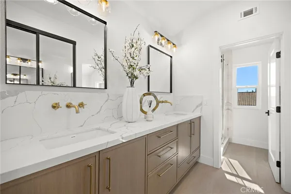 a spacious bathroom with a granite countertop double vanity sink and a mirror
