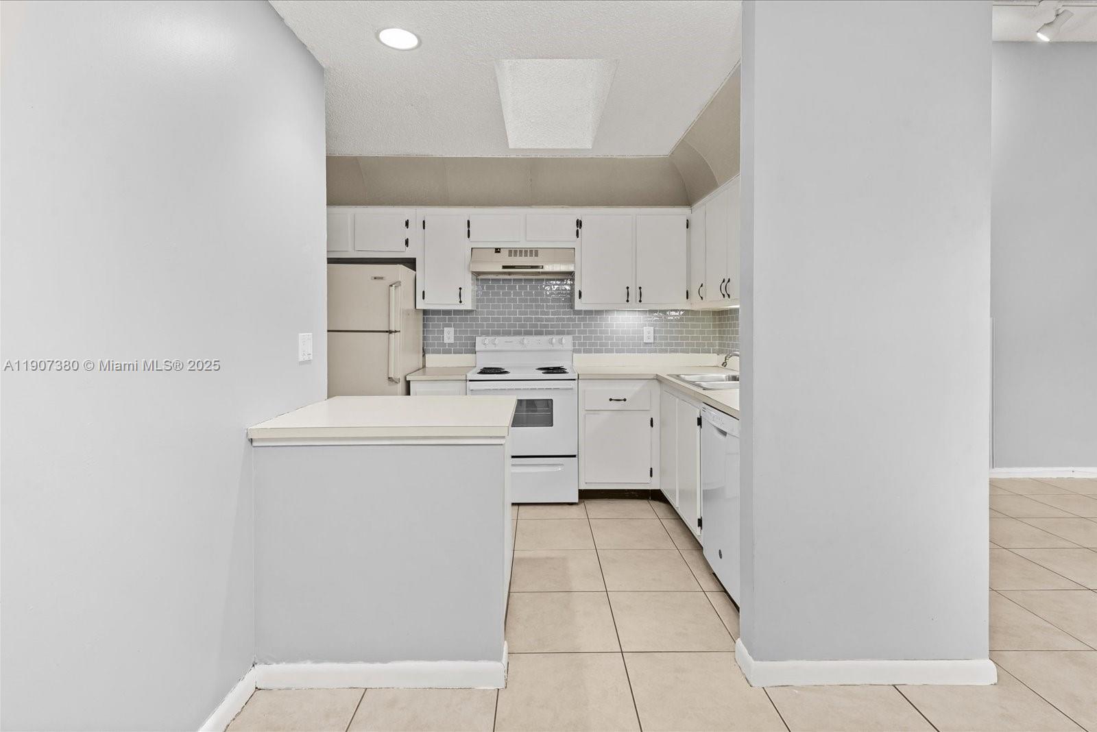 3502 Waterview Circle Palm Springs, FL 33461 - Photo 12 of 39 a kitchen with cabinets a sink and white appliances
