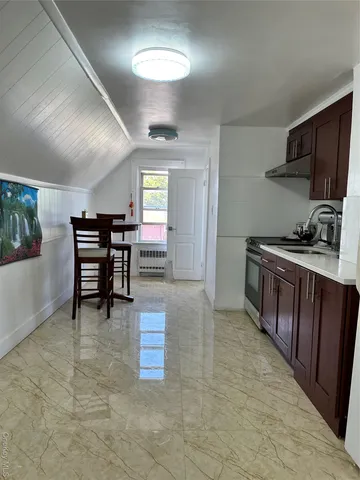 a kitchen with stainless steel appliances a stove a refrigerator a sink dishwasher with a dining table and chairs