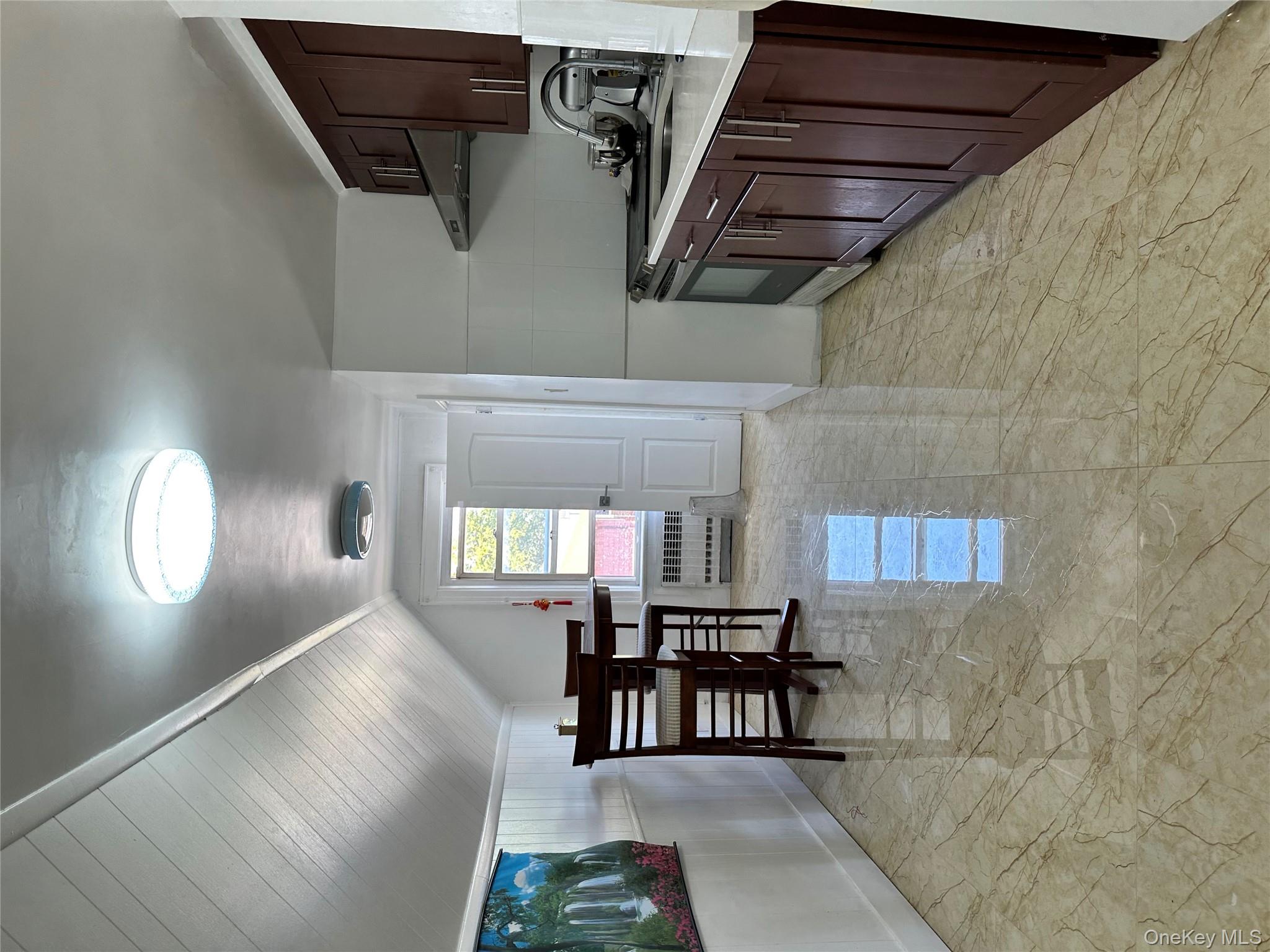 77-02 164th Street, Unit 3 Queens, NY 11366 - Photo 4 of 16 a kitchen with stainless steel appliances a stove a refrigerator a sink dishwasher with a dining table and chairs