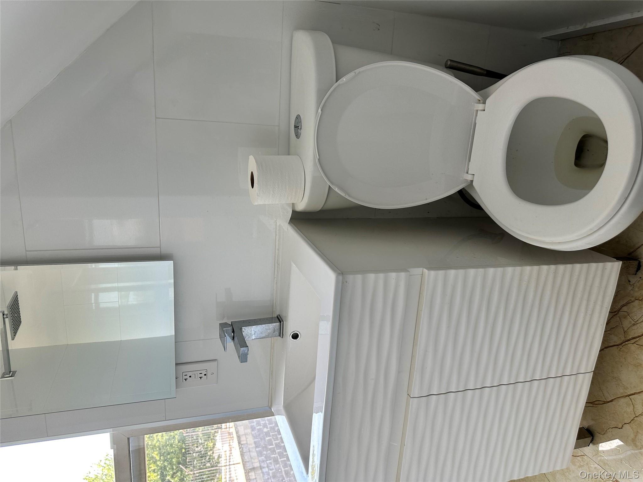 77-02 164th Street, Unit 3 Queens, NY 11366 - Photo 5 of 16 a white toilet sitting next to a bathroom sink