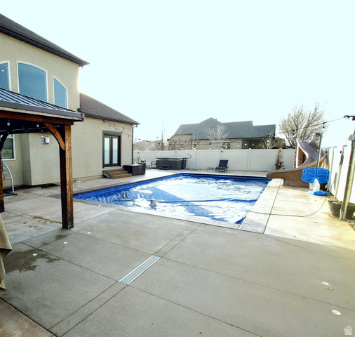 552 Sunset Crest Way Draper, UT 84020 - Photo 61 of 68 View of swimming pool featuring a patio, a water slide, a fenced backyard, a gazebo, and french doors