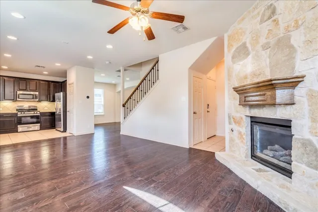 a view of a livingroom with a fireplace a ceiling fan and fire place