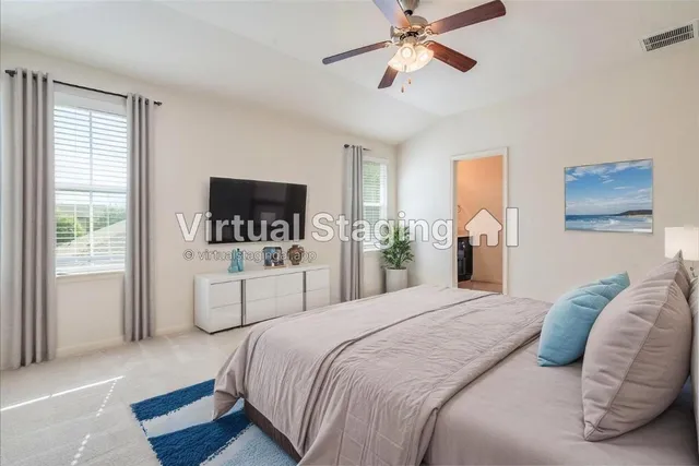 a spacious bedroom with a bed a window and a chandelier