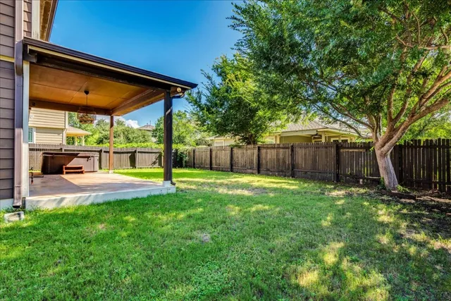 a view of a backyard with table and chairs under an umbrella