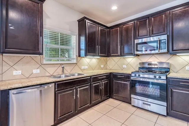 a kitchen with stainless steel appliances granite countertop a stove sink and cabinets