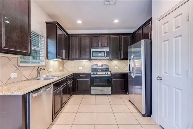 a kitchen with stainless steel appliances granite countertop a refrigerator and a sink
