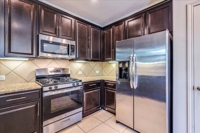 a kitchen with granite countertop stainless steel appliances and wooden cabinets
