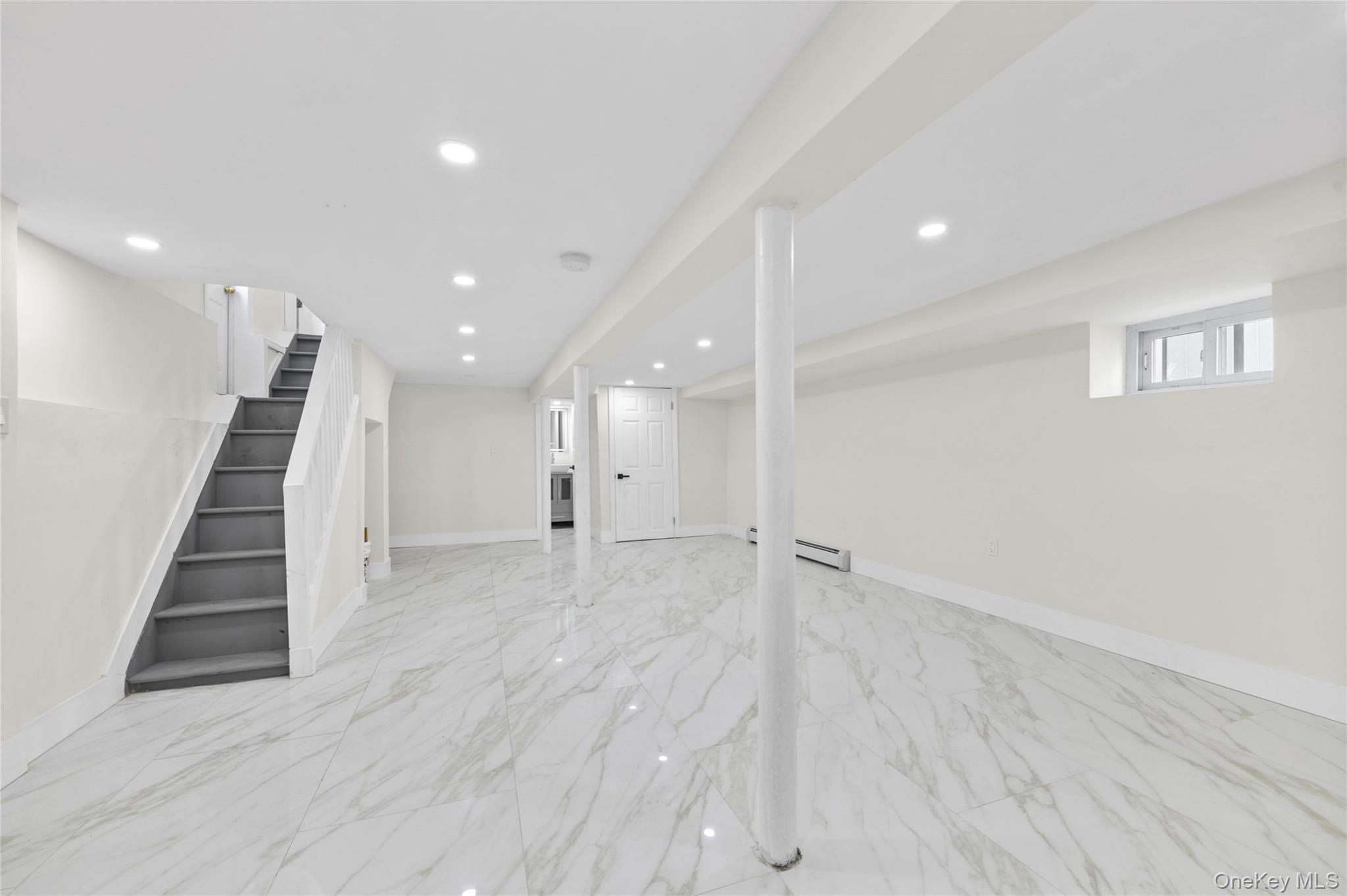 220-27 134th Road Queens, NY 11413 - Photo 15 of 22 Below grade area featuring stairway, light marble finish floors, recessed lighting, and baseboard heating