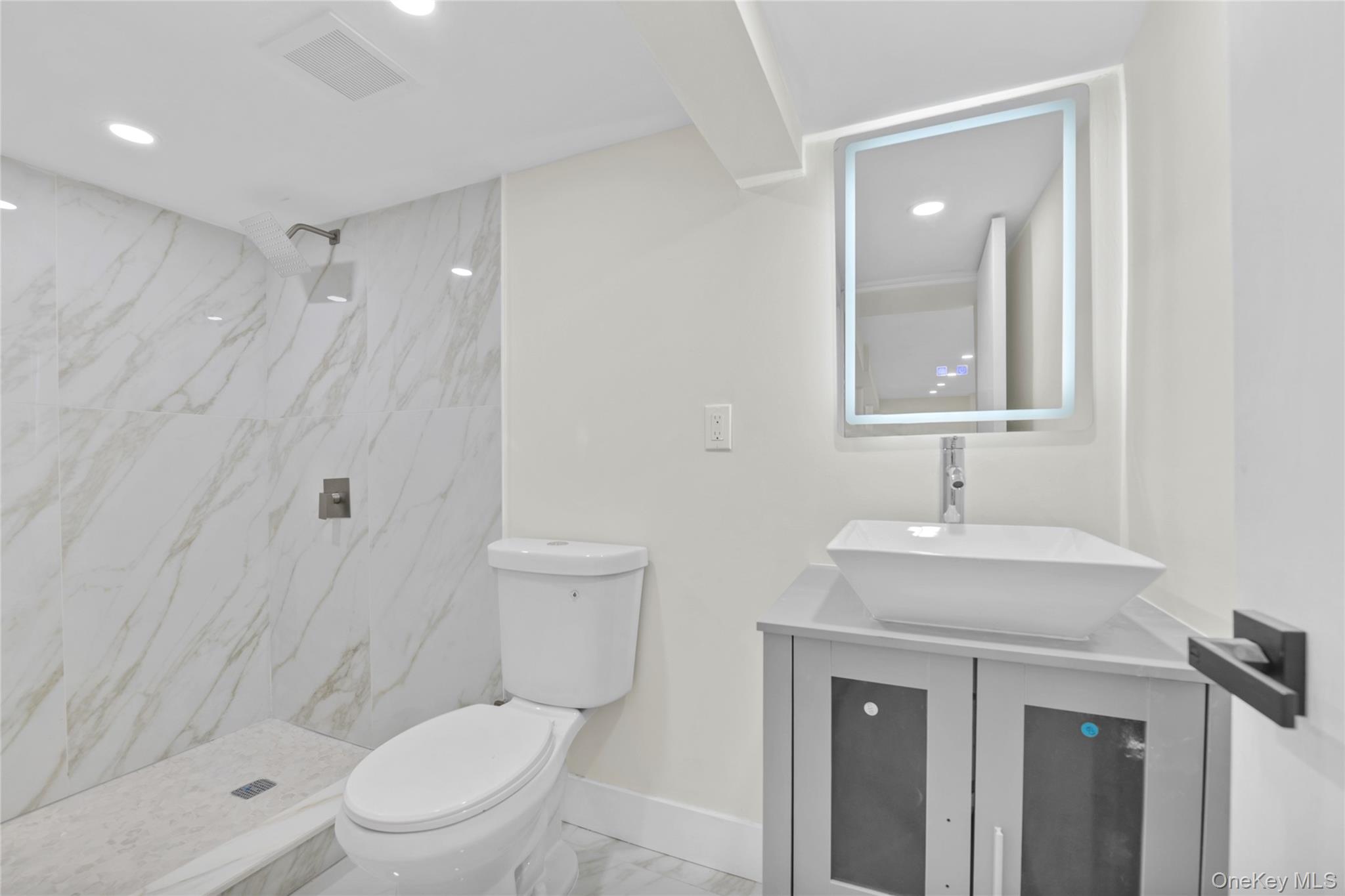 220-27 134th Road Queens, NY 11413 - Photo 17 of 22 Bathroom featuring vanity, a marble finish shower, light marble finish floors, and recessed lighting