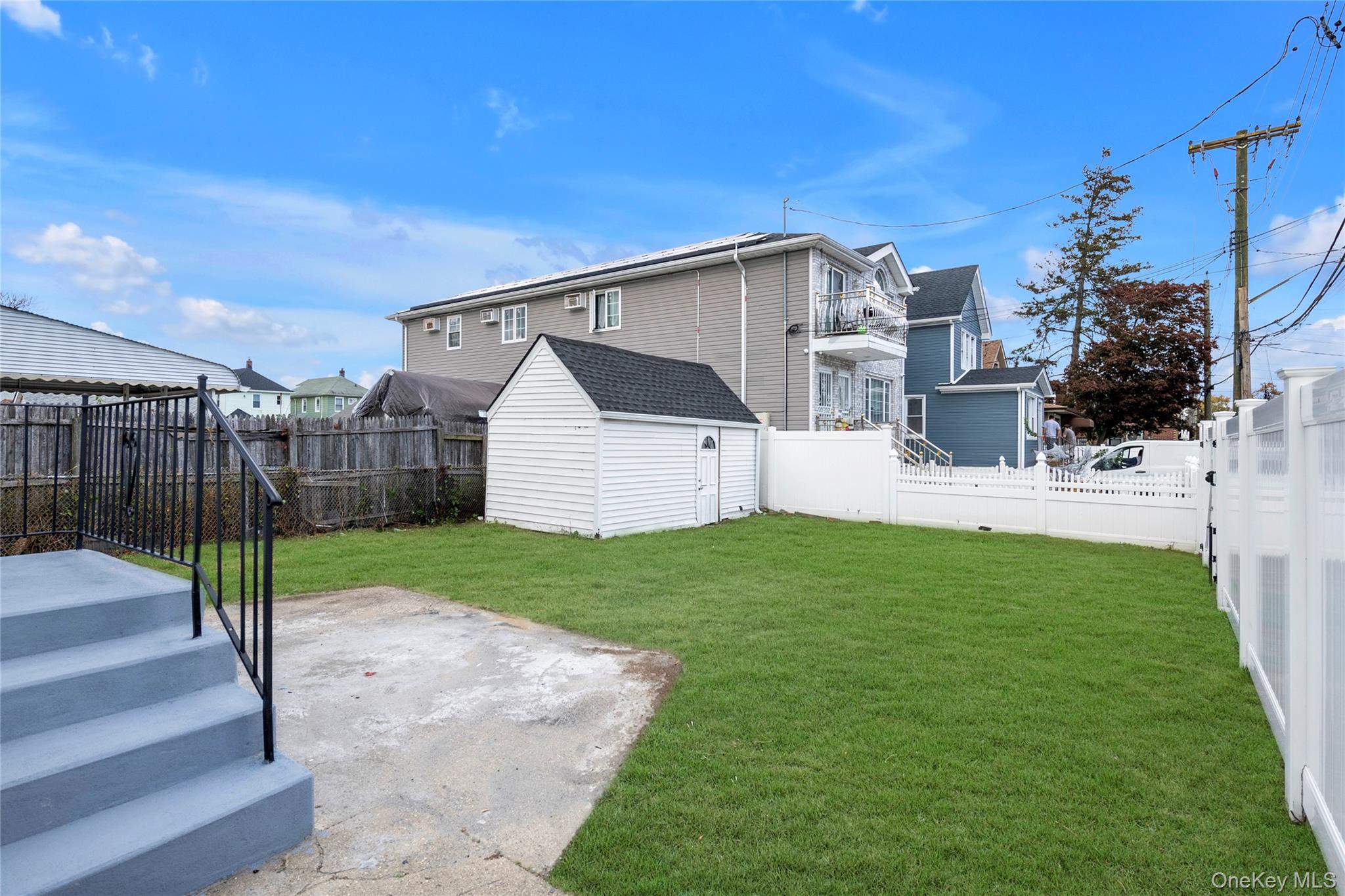 220-27 134th Road Queens, NY 11413 - Photo 20 of 22 Fenced backyard featuring a shed and a patio