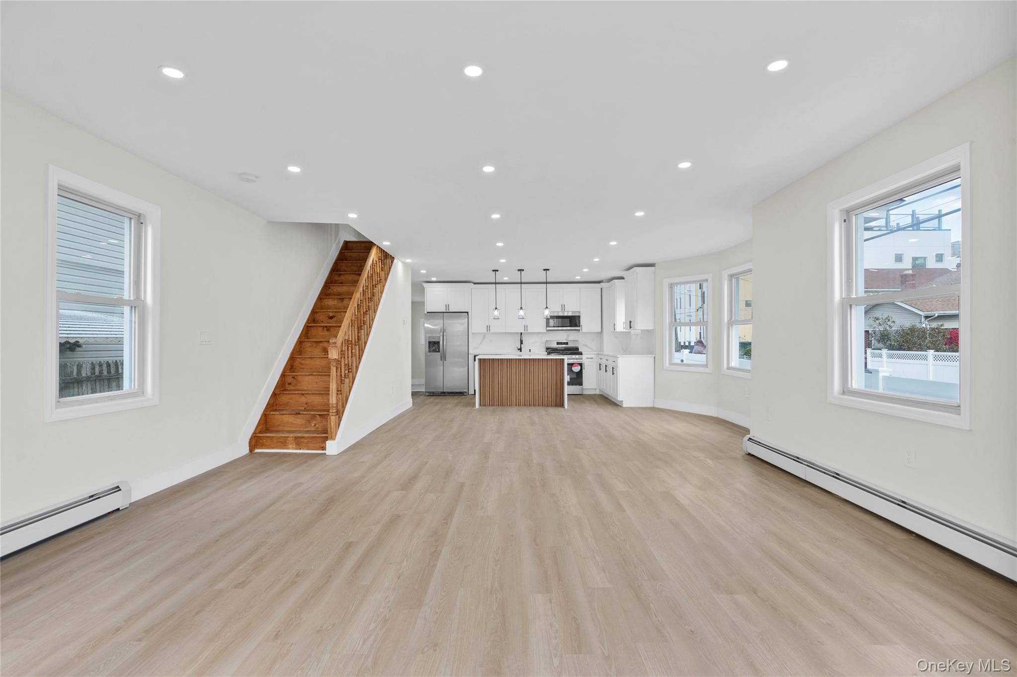220-27 134th Road Queens, NY 11413 - Photo 3 of 22 Unfurnished living room featuring recessed lighting, light wood finished floors, stairs, and baseboard heating