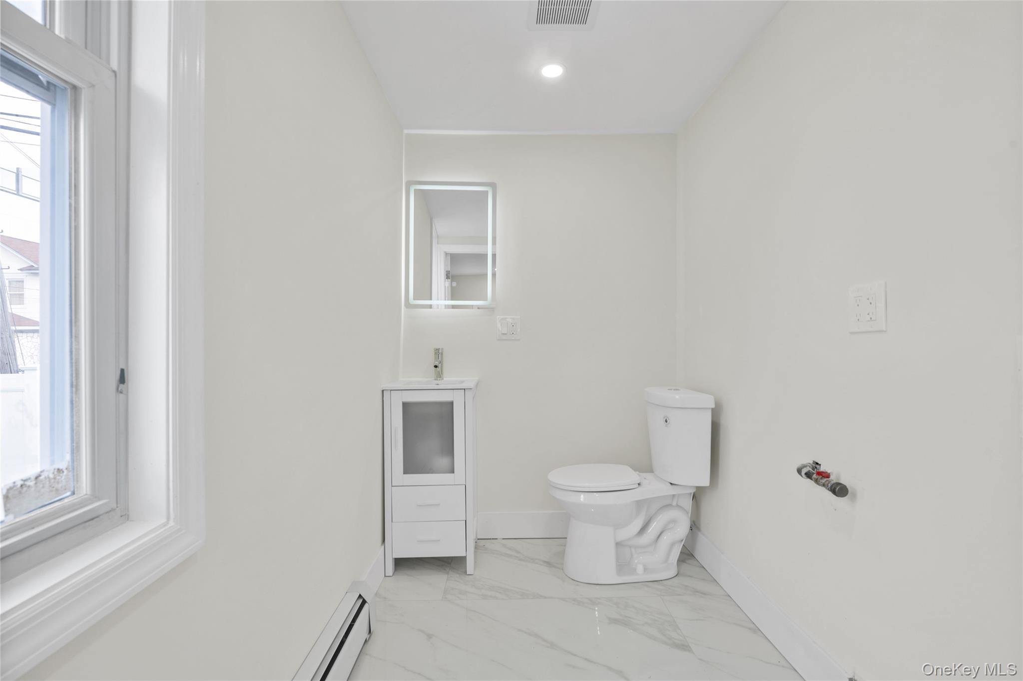 220-27 134th Road Queens, NY 11413 - Photo 8 of 22 Bathroom featuring a baseboard radiator, light marble finish floors, vanity, and recessed lighting