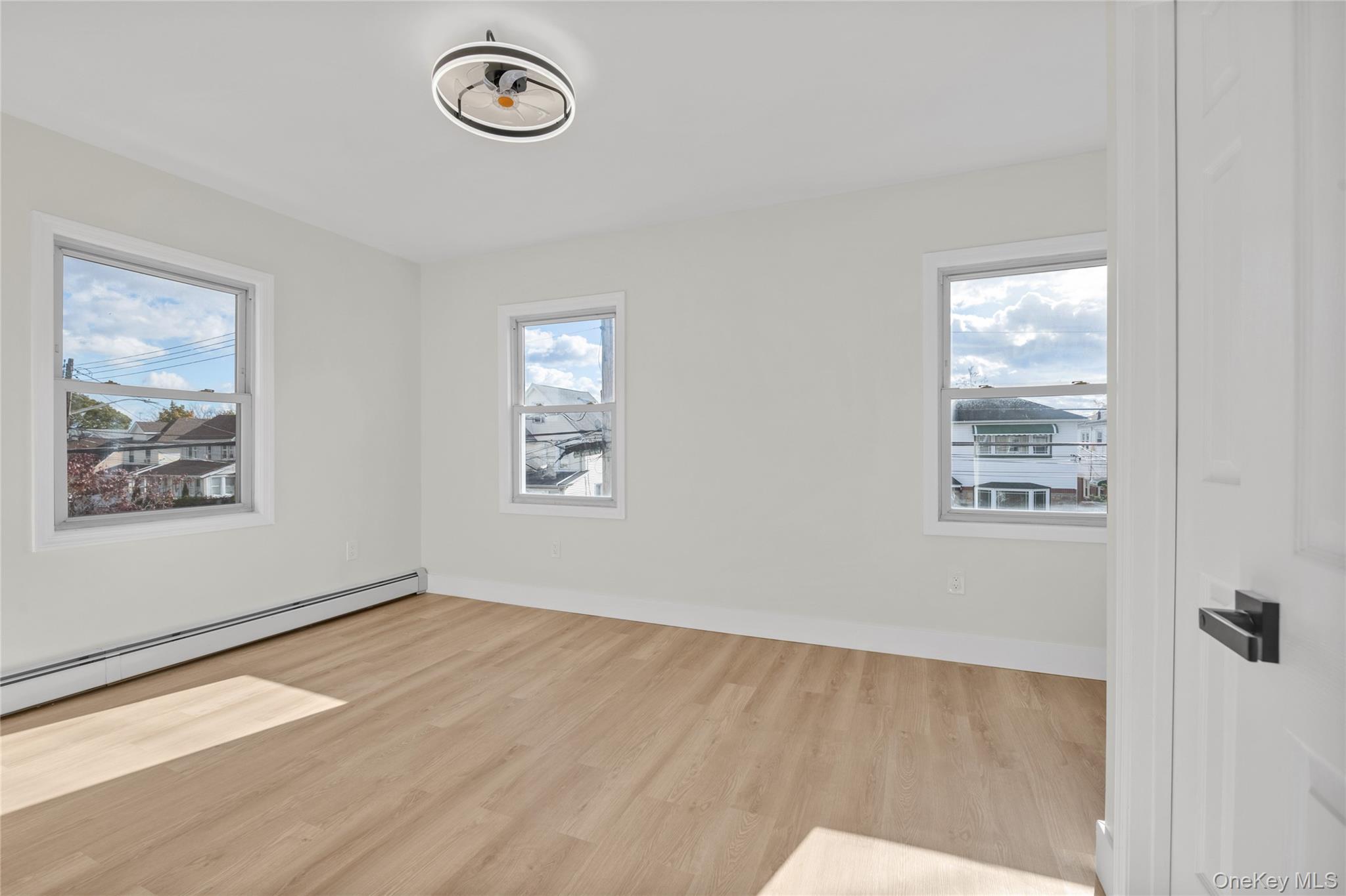 220-27 134th Road Queens, NY 11413 - Photo 9 of 22 Unfurnished room featuring light wood finished floors and plenty of natural light
