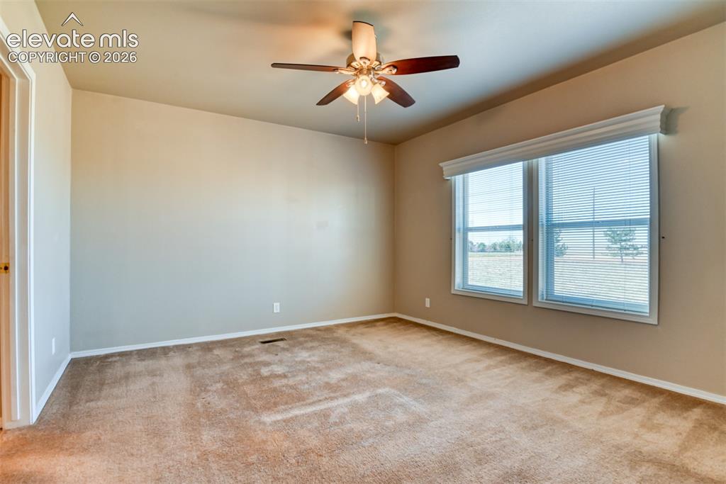 22558 Enoch Road Calhan, CO 80808 - Photo 11 of 50 an empty room with windows and fan