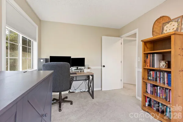 a view of a workspace with furniture and a bookshelf