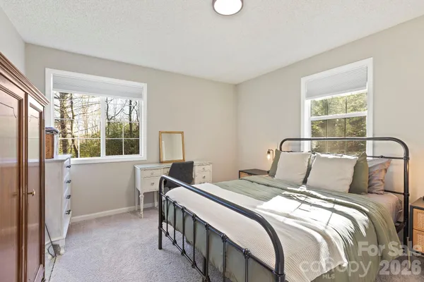 a bedroom with a bed and a large window