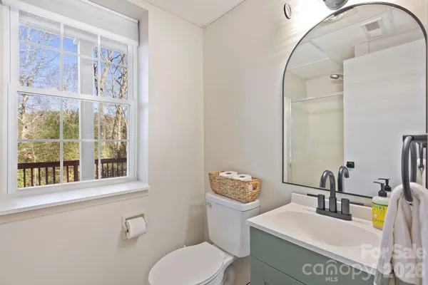 a bathroom with a toilet sink vanity and mirror
