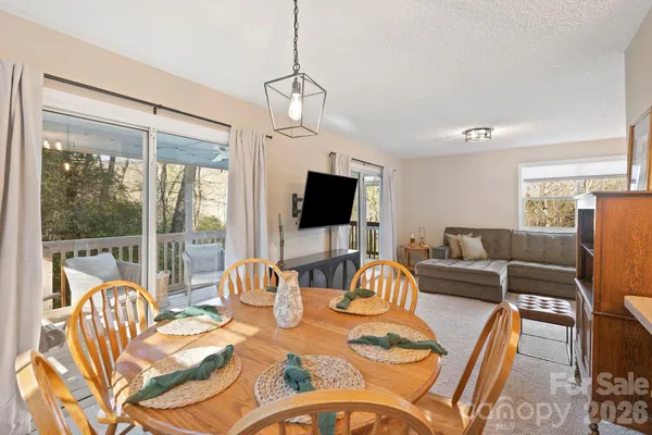a living room with furniture a flat screen tv and large windows