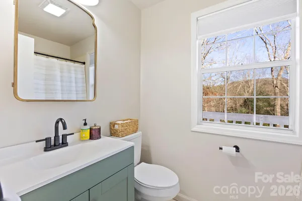 a bathroom with a sink vanity mirror and toilet
