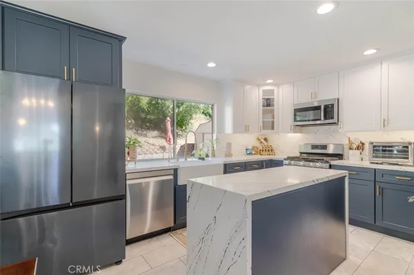 a kitchen with stainless steel appliances granite countertop a refrigerator sink stove microwave and cabinets