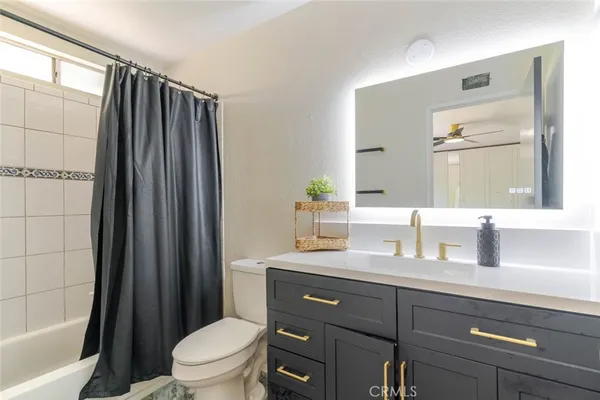 a bathroom with a granite countertop sink toilet a large mirror a vanity and shower