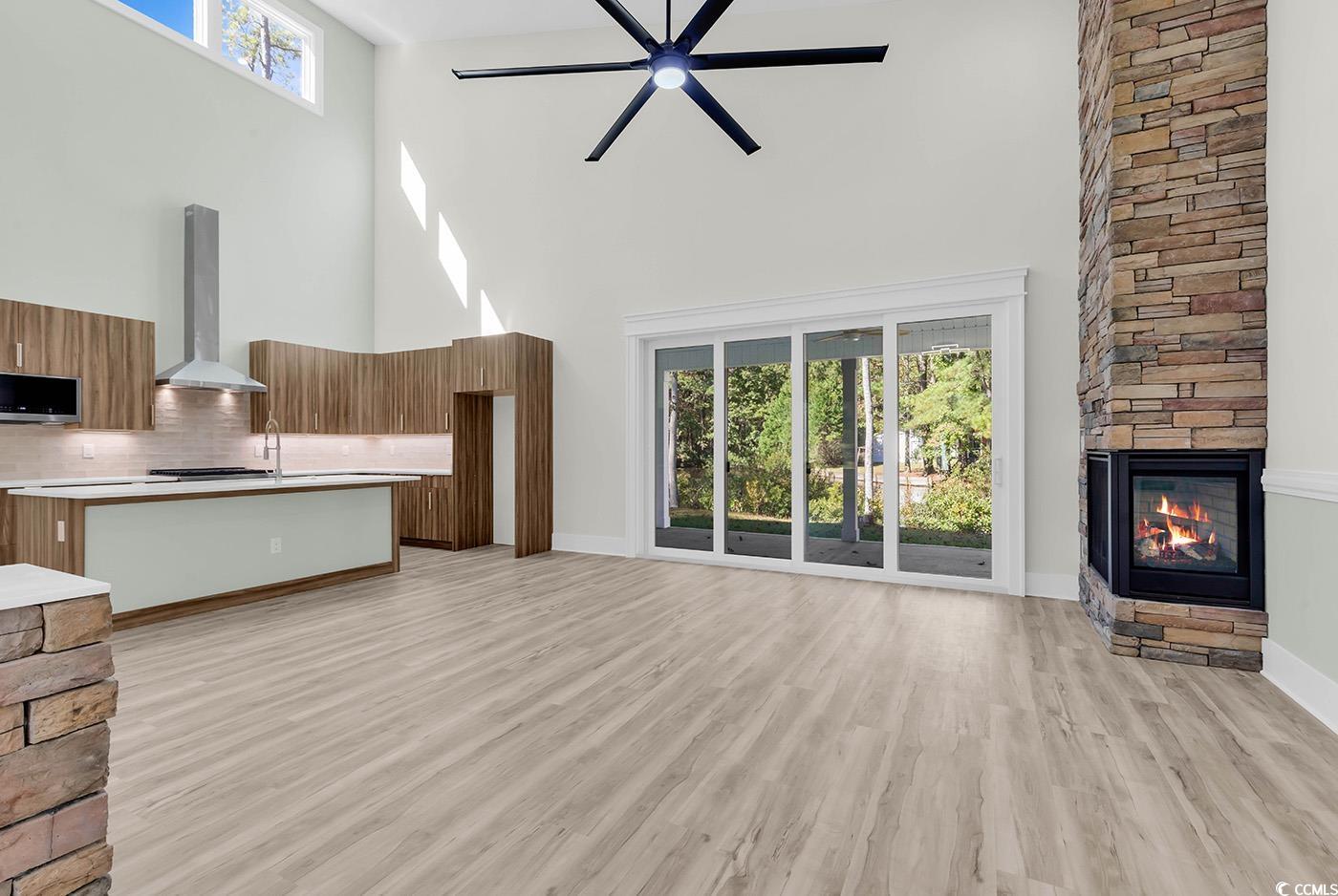 1028 Colette Court Conway, SC 29526 - Photo 2 of 39 Unfurnished living room with a fireplace, a high ceiling, light wood finished floors, and a ceiling fan
