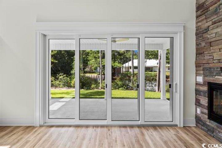 1028 Colette Court Conway, SC 29526 - Photo 9 of 39 Doorway to outside featuring wood finished floors, healthy amount of natural light, and a fireplace