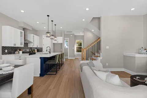 a kitchen with kitchen island a white counter top space a sink stainless steel appliances and cabinets