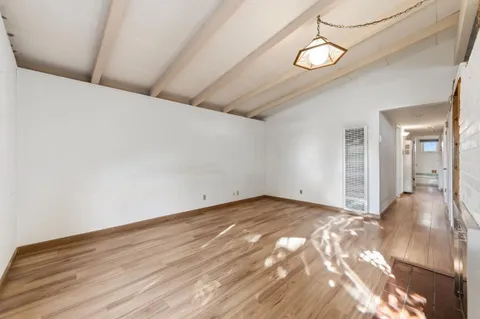 a view of an empty room with wooden floor