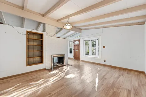 a view of a livingroom with a fireplace and window