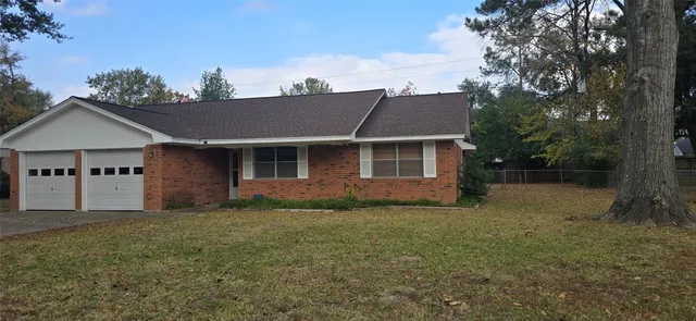 a view of a yard in front of a house with large tree