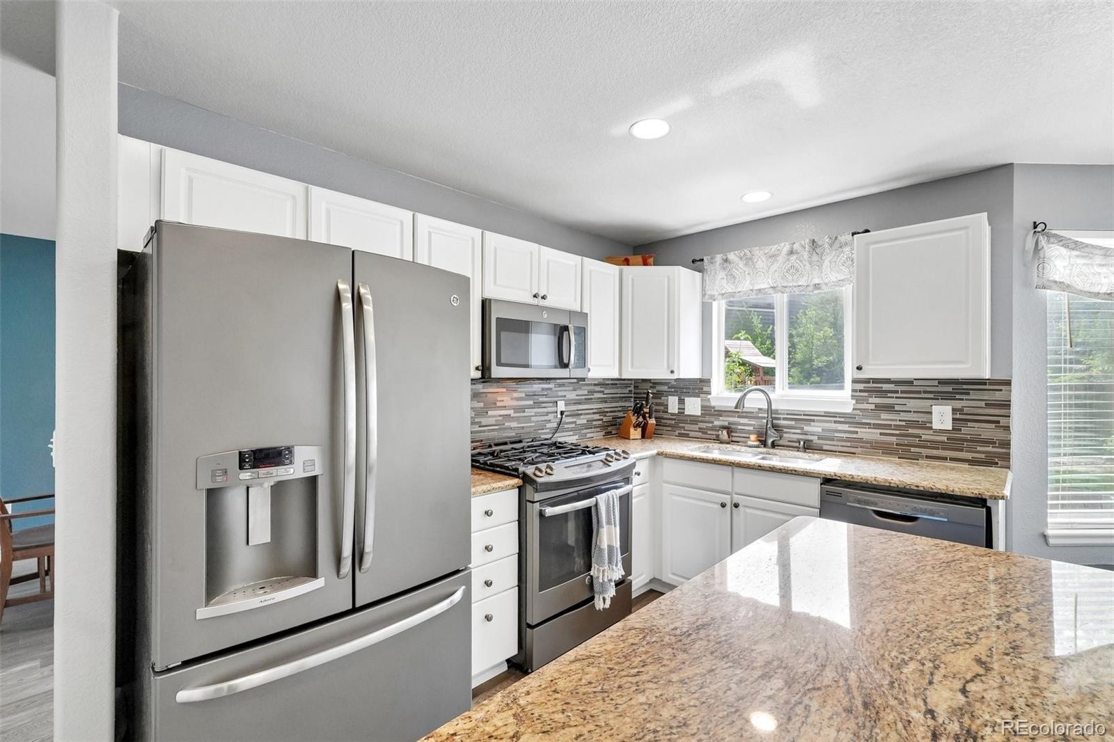 6642 Tiger Tooth Lone Tree, CO 80124 - Photo 23 of 44 a kitchen with stainless steel appliances granite countertop a refrigerator a stove and a sink