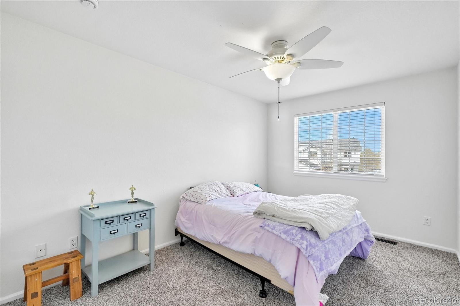 6642 Tiger Tooth Lone Tree, CO 80124 - Photo 29 of 44 a bedroom with a bed and a chandelier