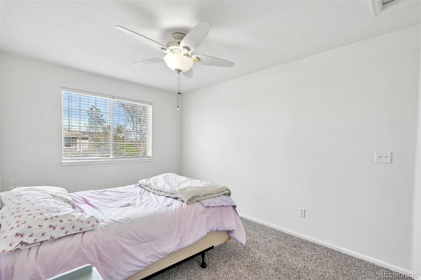 6642 Tiger Tooth Lone Tree, CO 80124 - Photo 30 of 44 a bedroom with a bed and a window