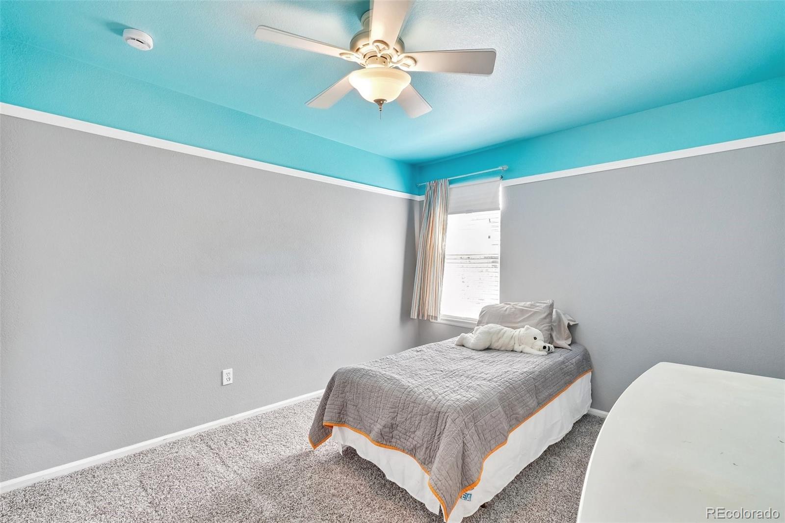 6642 Tiger Tooth Lone Tree, CO 80124 - Photo 32 of 44 a bedroom with a bed and a ceiling fan