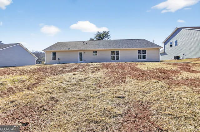 a view of an house with backyard space and balcony