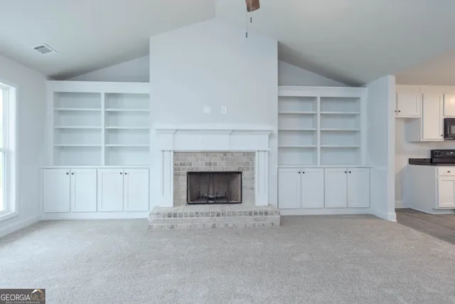 a view of an empty room with a fireplace and cabinet