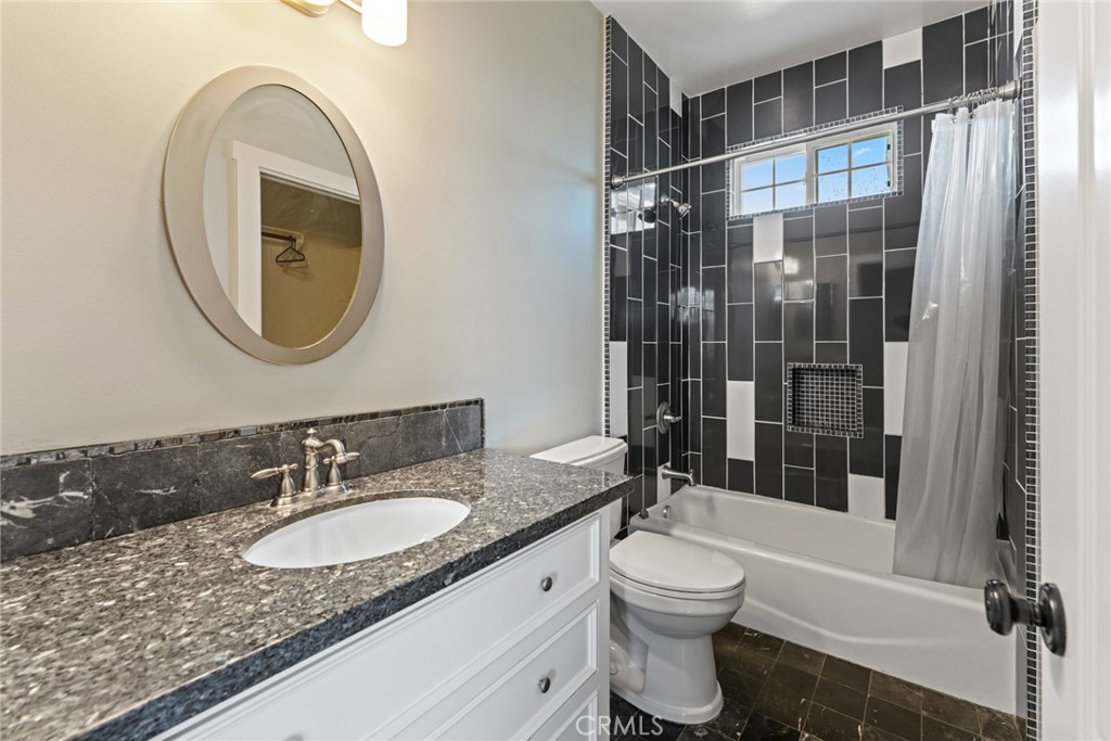 5836 Buckthorn Avenue Rancho Cucamonga, CA 91737 - Photo 16 of 63 a bathroom with a granite countertop sink toilet mirror and shower