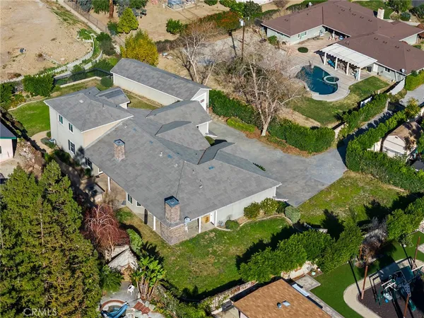 an aerial view of a house with swimming pool and a yard