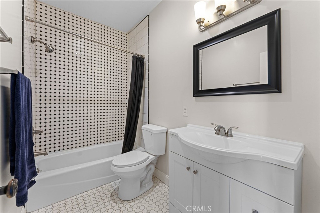 5836 Buckthorn Avenue Rancho Cucamonga, CA 91737 - Photo 53 of 63 a bathroom with a toilet sink vanity and mirror
