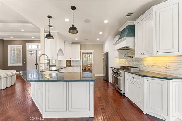 a large kitchen with stainless steel appliances lots of counter space and wooden floors