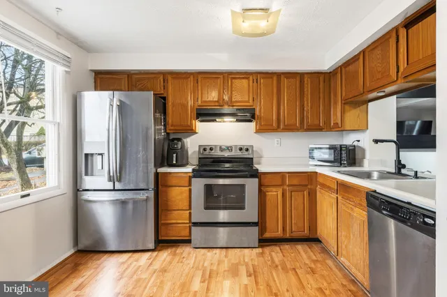 a kitchen with granite countertop stainless steel appliances and wooden cabinets