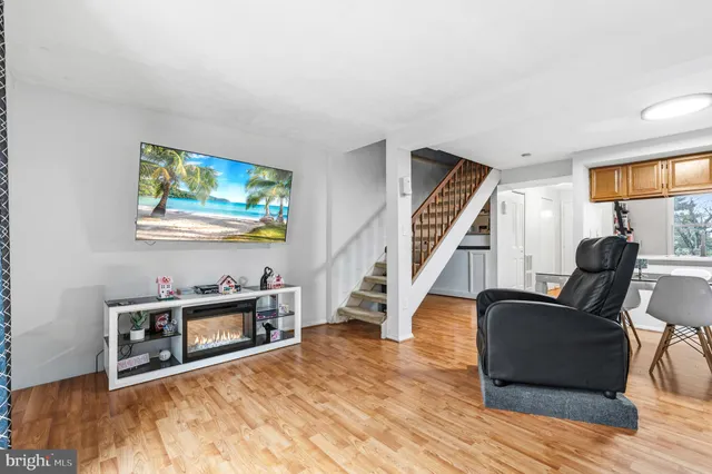 a living room with furniture and a flat screen tv with wooden floor