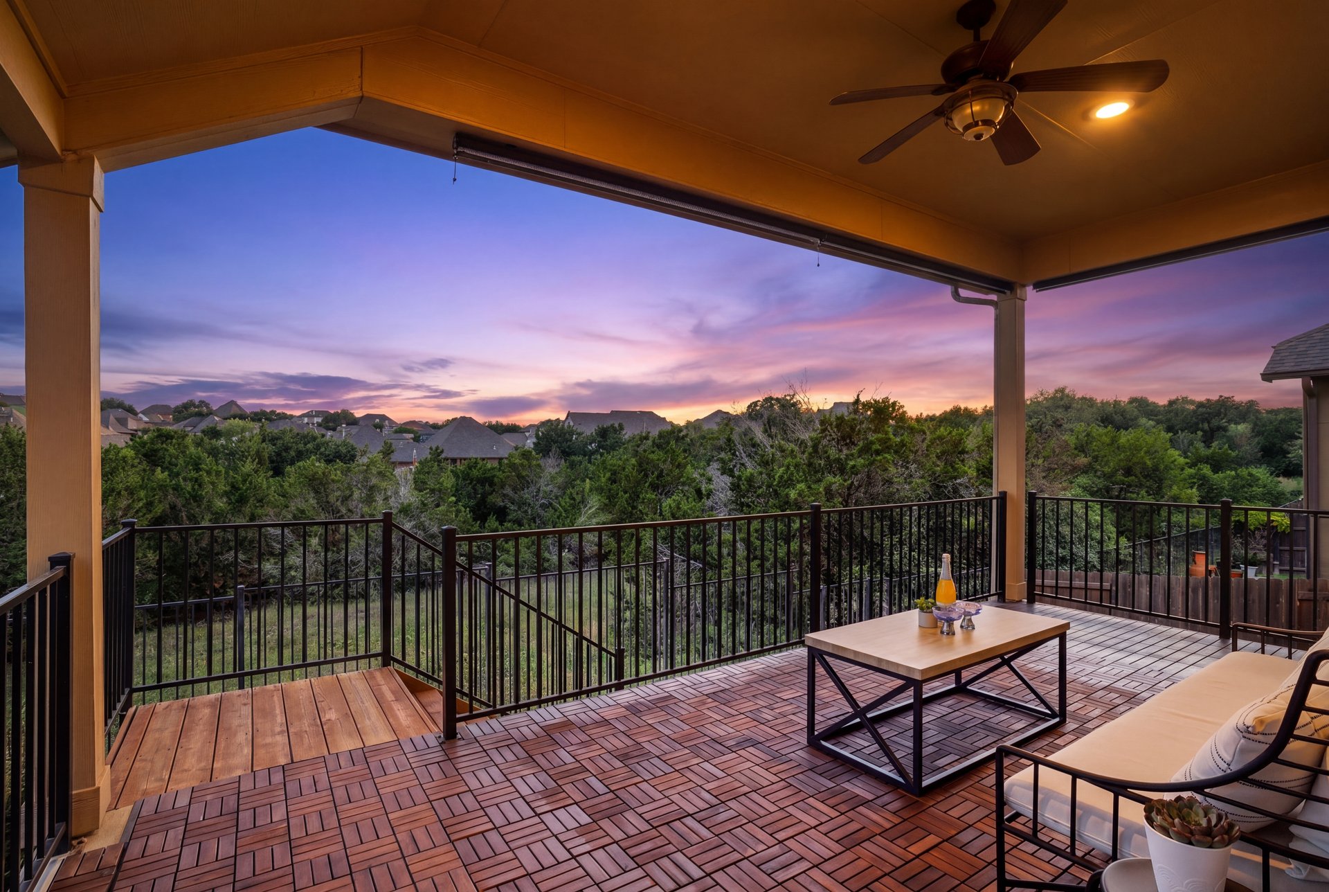 173 Santa Maria Street Georgetown, TX 78628 - Photo 2 of 39 Covered outdoor deck featuring wood-finish flooring with a contrasting wood-finish landing, black metal railings, and a ceiling fan with integrated lighting