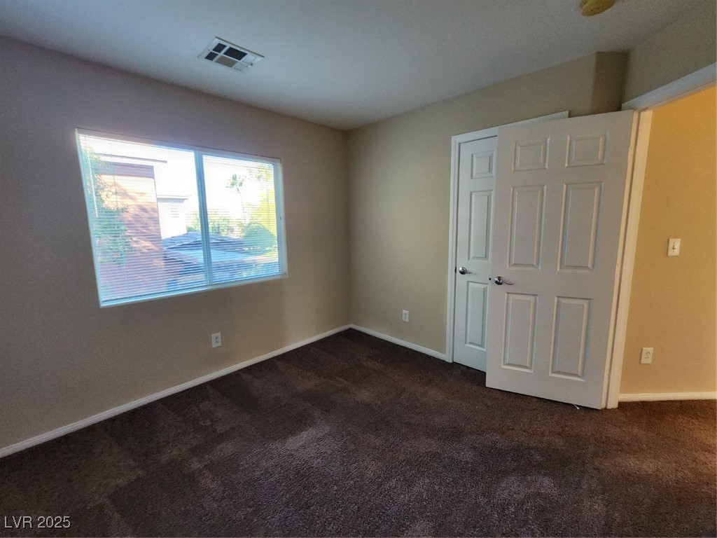 9409 Crimson Sky Street Las Vegas, NV 89178 - Photo 21 of 46 Unfurnished bedroom featuring dark carpet and baseboards