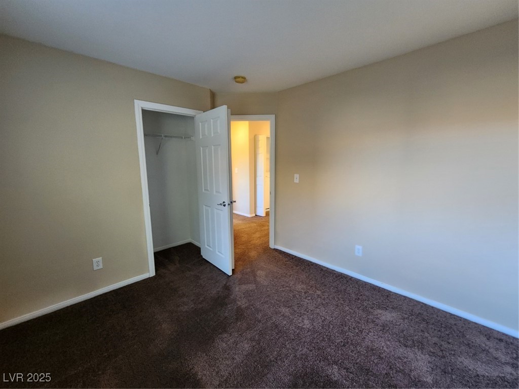 9409 Crimson Sky Street Las Vegas, NV 89178 - Photo 22 of 46 Unfurnished bedroom featuring a closet and dark carpet