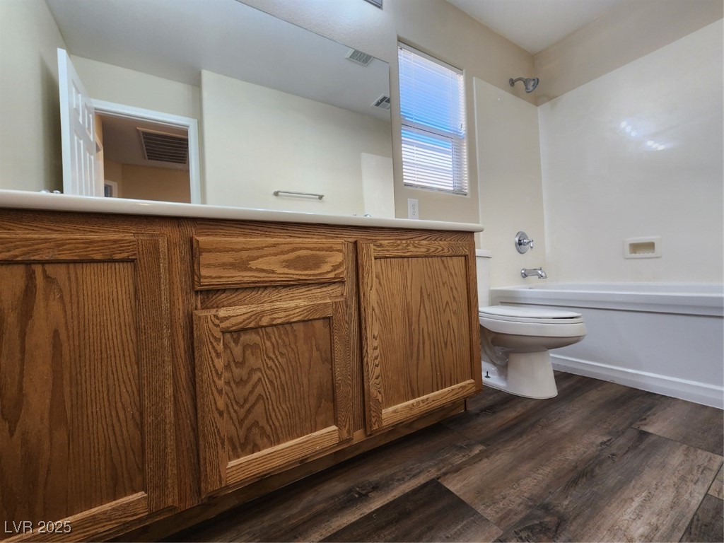 9409 Crimson Sky Street Las Vegas, NV 89178 - Photo 27 of 46 Bathroom featuring dark wood-style flooring, vanity, and shower / tub combination
