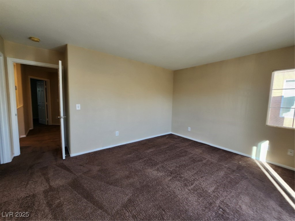 9409 Crimson Sky Street Las Vegas, NV 89178 - Photo 32 of 46 Unfurnished room featuring dark colored carpet and baseboards