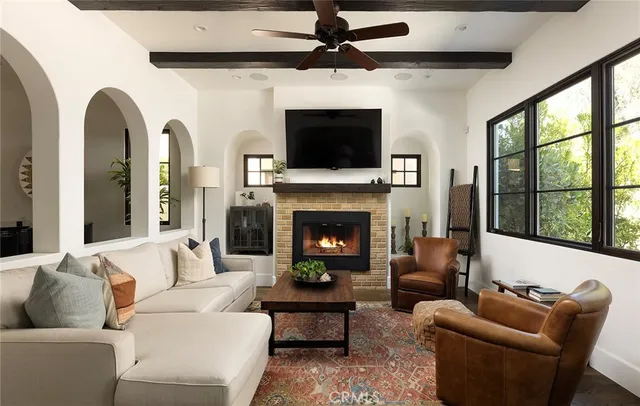 a living room with furniture a flat screen tv and a fireplace